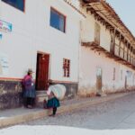 two women talking while standing near building duting daytime