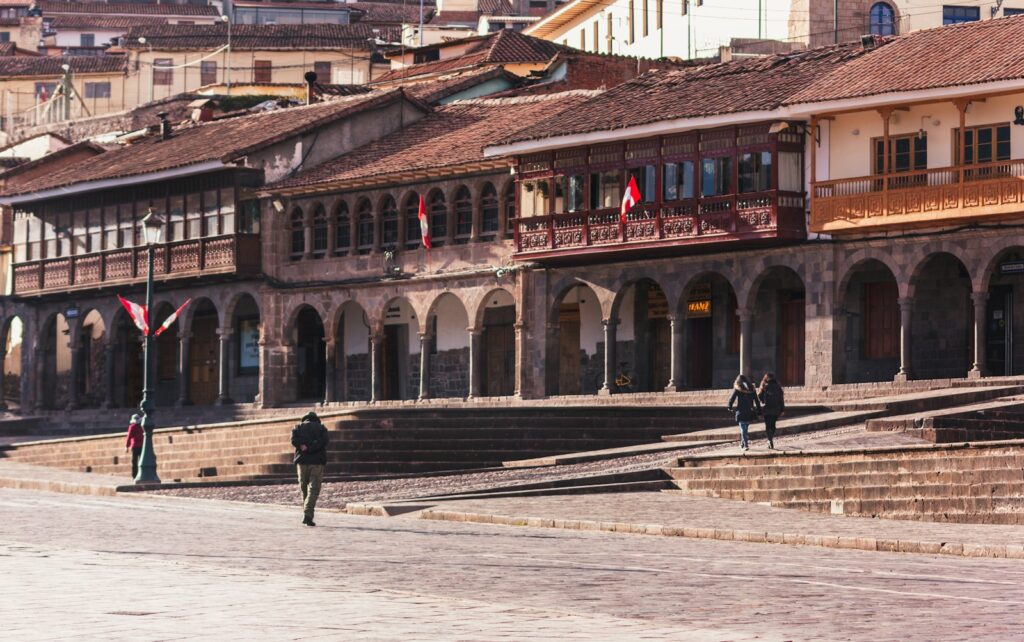 a man walking down a street next to tall buildings